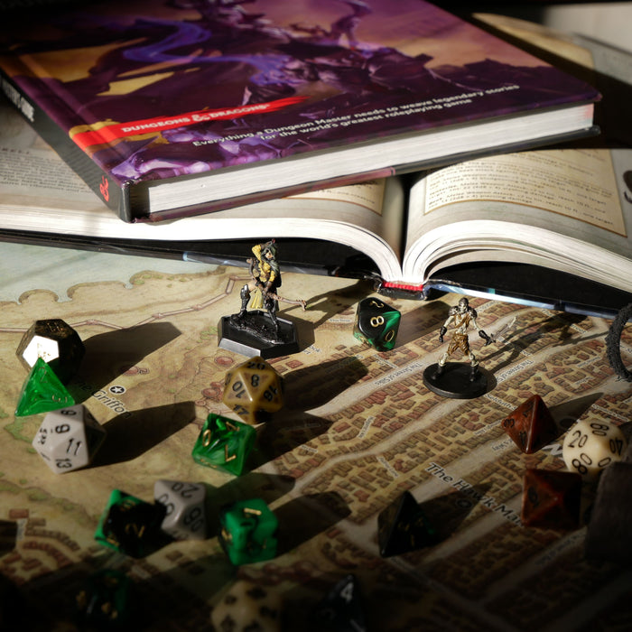 Fantasy miniature figures and polyhedral dice arranged on a tabletop RPG game map