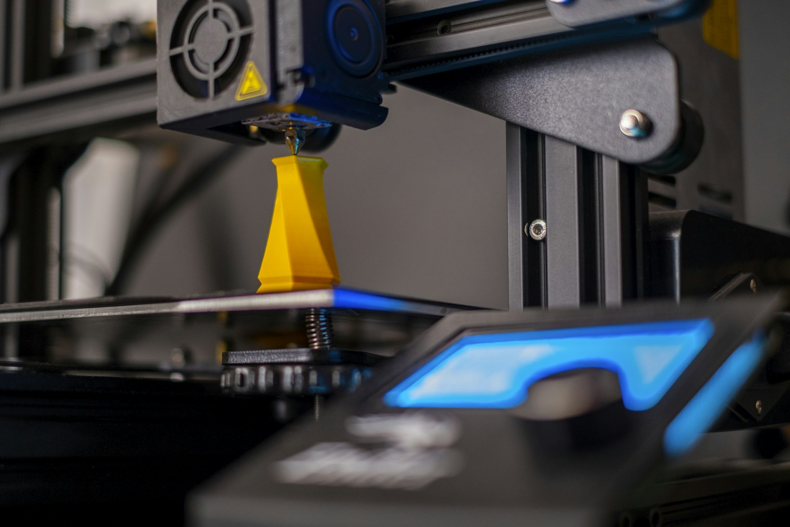 A 3D printer extruding filament to build a model to order, illustrating print-on-demand miniatures