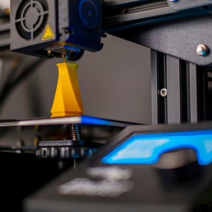 A 3D printer extruding filament to build a model to order, illustrating print-on-demand miniatures