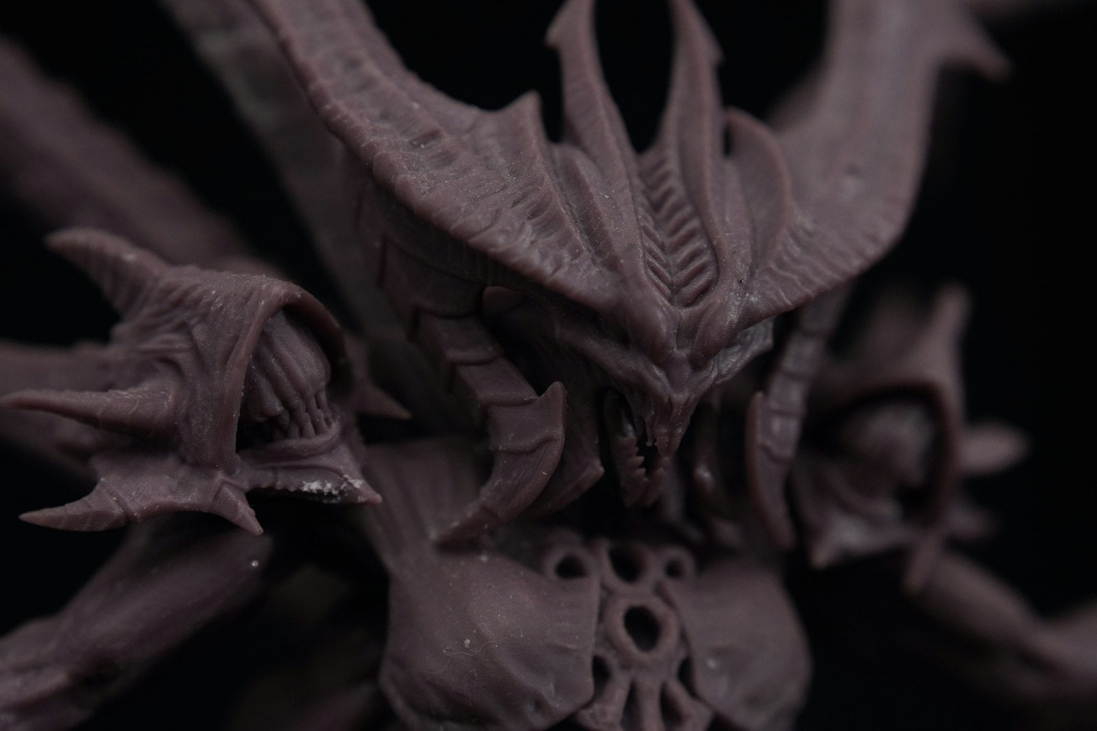 A bare grey resin 3D-printed fantasy demon miniature, unpainted and ready for cleaning and priming