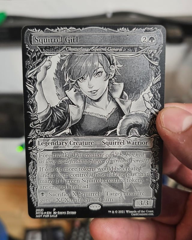 Hand holding a custom engraved metal trading card to show size