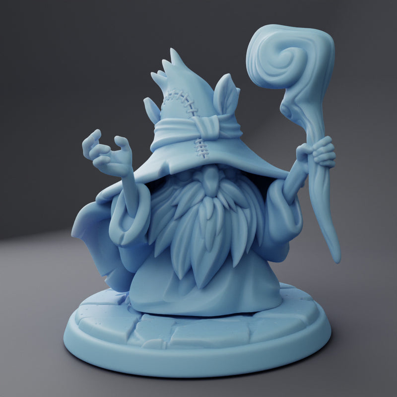 A resin-printed miniature figurine of a bearded wizard wearing a hat and holding a staff, unpainted and on a grey base.